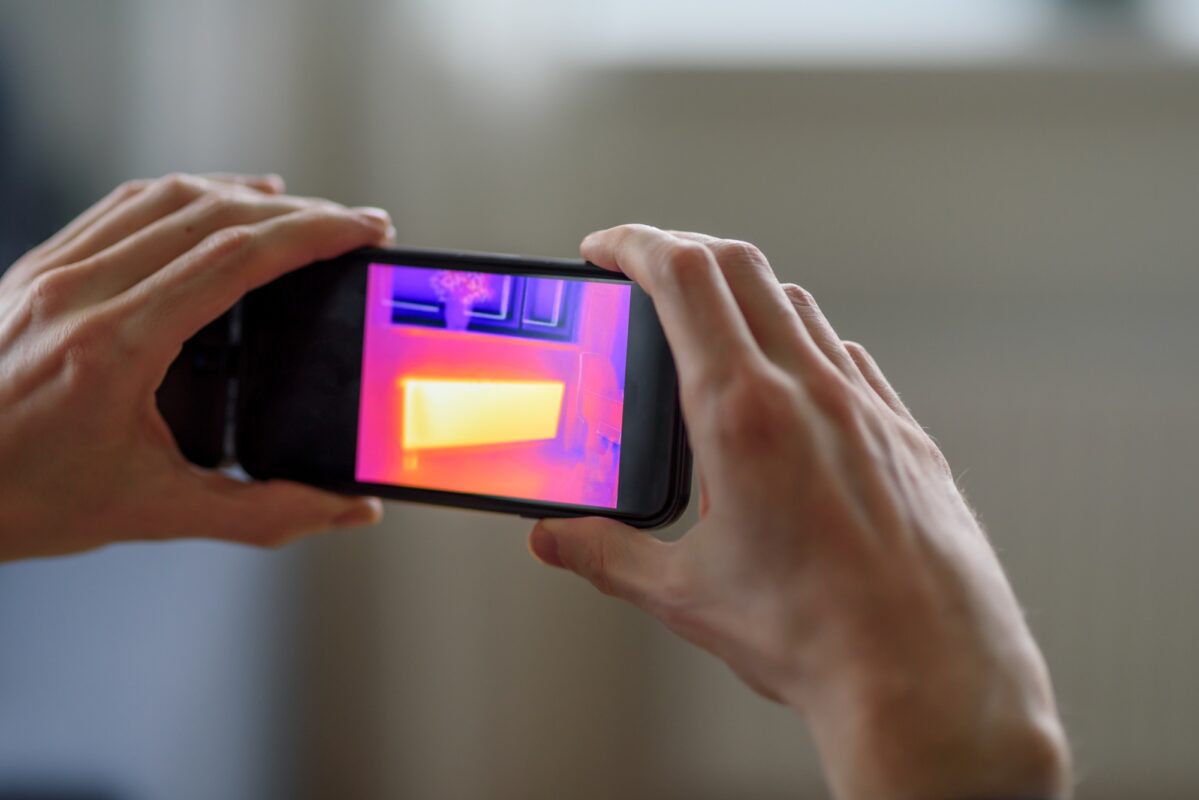 Person doing thermal scanning of apartment
